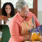 Three generations of Black women cooking in kitchen