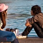 A teenage couple enjoy the sun by one of the Trafalgar Square fountains.